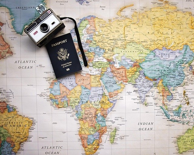 Passport and camera on a world map for travel planning